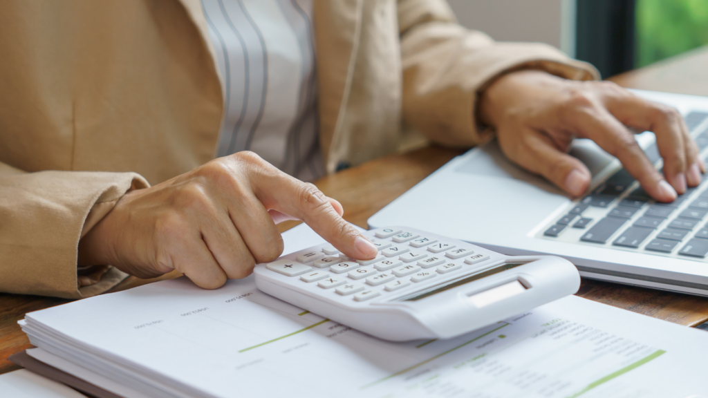 Custos ocultos ao abrir uma farmácia. Imagem mostra uma mulher fazendo contas em uma calculadora